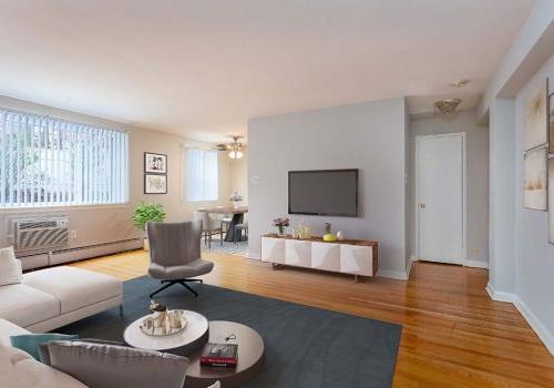 Living room with a couch, chair, and TV at Eola Park apartments for rent in Philadelphia, PA